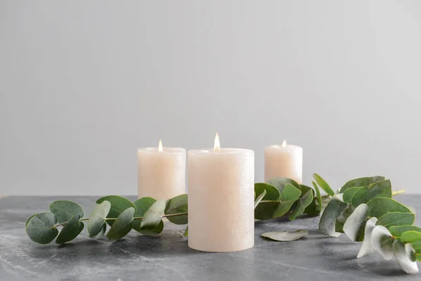 Burning Candles Eucalyptus Branches Grey Table — Stock Photo, Image