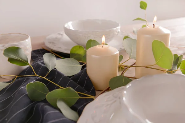 Burning Candles Eucalyptus Branches Dishware Wooden Table — Stock Photo, Image