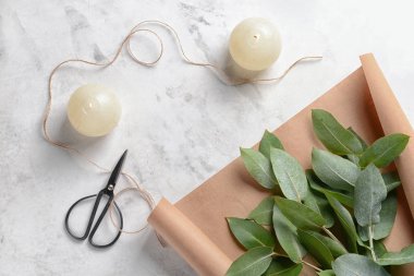 Okaliptüs yaprakları ve açık renkli kağıda ile yanan mumlar