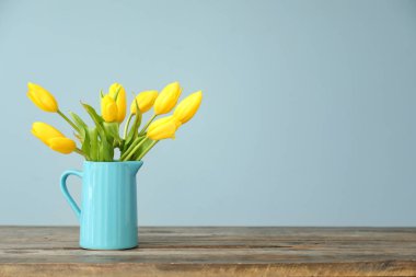 Ahşap masa üzerinde güzel lale ile sürahi