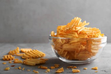 Gri masada lezzetli çıtır patates cipsi ile kase