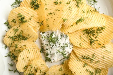 Ekşi krema ve dereotu plaka, closeup ile lezzetli çıtır patates cipsi