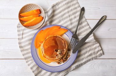 Trabzon hurması ve bal beyaz ahşap masanın üzerine dilimlenmiş sıcak lezzetli gözleme ile plaka