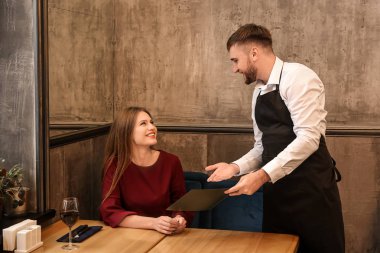 Genç garson kadın bir menü restoranda gösterilen.