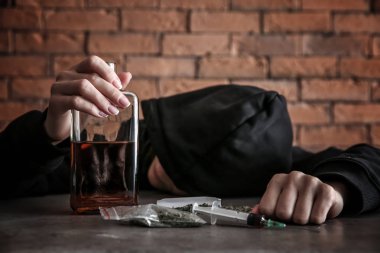 Alkol ve uyuşturucu gri masada ile kadın keş. Bağımlılık kavramı