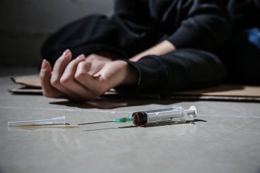 Kadın bağımlısı uyuşturucu aldıktan sonra yerde yatıyor. Bağımlılık kavramı