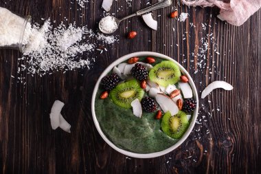 Koyu ahşap masa üzerinde lezzetli spirulina güler yüzlü ile kase