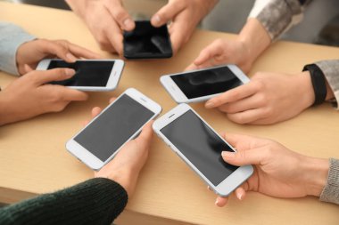 Cep telefonları ahşap masa kullanan gençlerin. Bağımlılık kavramı