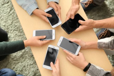 Cep telefonları ahşap masa kullanan gençlerin. Bağımlılık kavramı