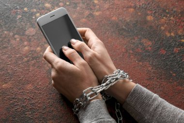 Kadın zincirleme elleriniz ve renk arka plan üstünde hareket eden telefon. Bağımlılık kavramı