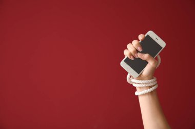 Ve kadın ile bağlı el renk arka plan üstünde hareket eden telefon. Bağımlılık kavramı