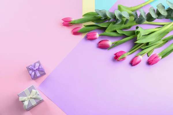 Beautiful tulips and gifts for Mother's Day on color background