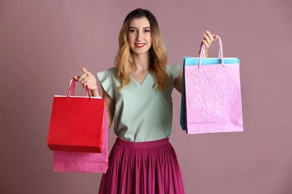 Красивая Молодая Женщина Пакетами Покупок Цветном Фоне — стоковое фото