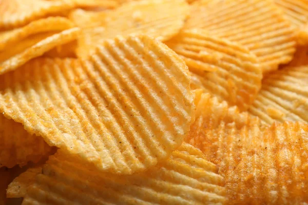 Many tasty crispy potato chips, closeup