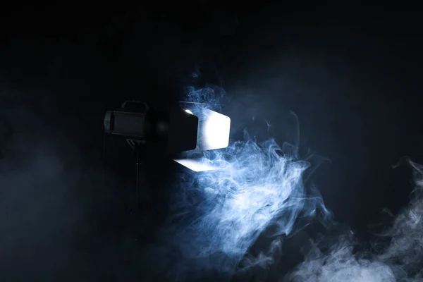 Professional lighting equipment with fume on dark background