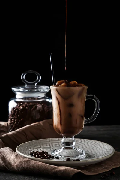 ダークウッドのテーブルにおいしい冷たいコーヒーとグラスに注いでチョコレートの — ストック写真