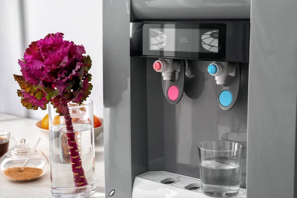 Modern water cooler on table in kitchen