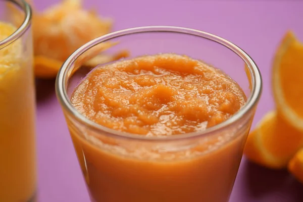 Glass of tasty orange smoothie, closeup