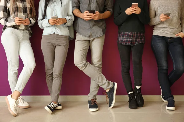 Les Jeunes Utilisant Des Téléphones Mobiles Près Mur Couleur Concept — Photo