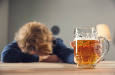 Masada bira içen bilinçsiz sarhoş adam. Alkolizm kavramı