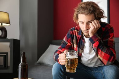 Depresif genç adam evde bira içiyor. Alkolizm kavramı
