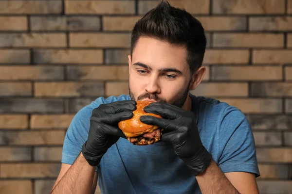 Genç Adam Kafede Lezzetli Hamburger Yeme — Stok fotoğraf