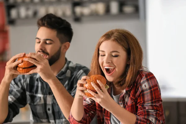 Young Couple Eating Tasty Burgers Home — Stock Photo, Image