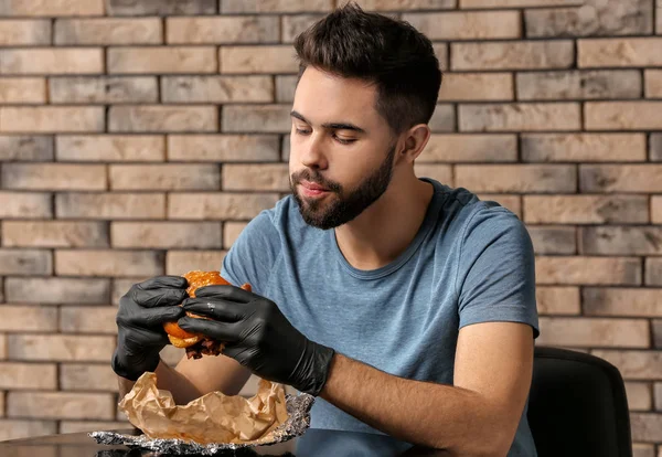 Genç Adam Kafede Lezzetli Hamburger Yeme — Stok fotoğraf