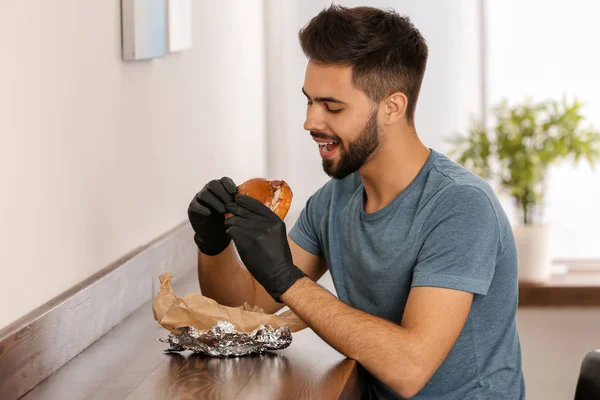 Νεαρός Άνδρας Τρώει Νόστιμο Burger Στο Καφέ — Φωτογραφία Αρχείου