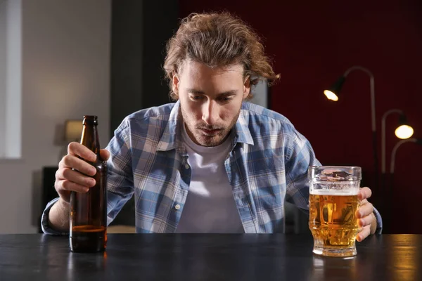 落ち込んで若い男のテーブルでビールを飲みます アルコール依存症の概念 — ストック写真