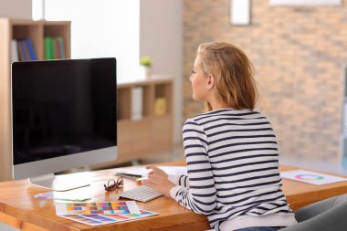 Güzel genç tasarımcı ofiste çalışıyor.