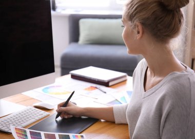 Güzel genç tasarımcı ofiste çalışıyor.