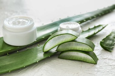 Kavanoz krem ve beyaz dokulu arka plan üzerinde aloe healing ile