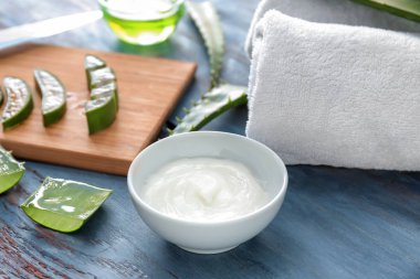 Krem ve ahşap masa üzerinde aloe şifa ile kase