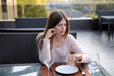 Genç kadın sevgilisi kafede beklenirken bakarak