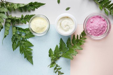 Kozmetik ürünleri ile eğreltiotu yaprakları renk arka plan üzerinde