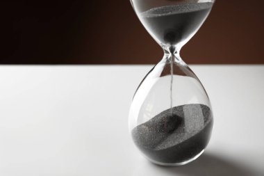 Düşme ile kristal kum saati beyaz masaya kum. Son Tarih kavramı