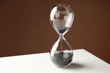 Düşme ile kristal kum saati beyaz masaya kum. Son Tarih kavramı