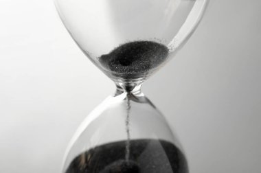 Düşme ile kristal kum saati gri arka plan üzerinde kum. Son Tarih kavramı