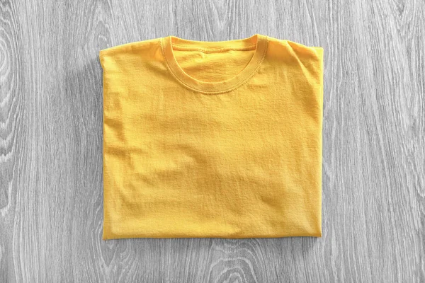 Blank yellow t-shirt on wooden background