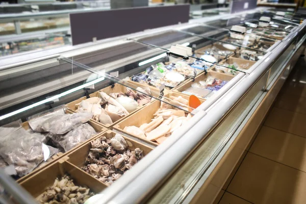 Refrigerator with assortment of frozen seafood in store