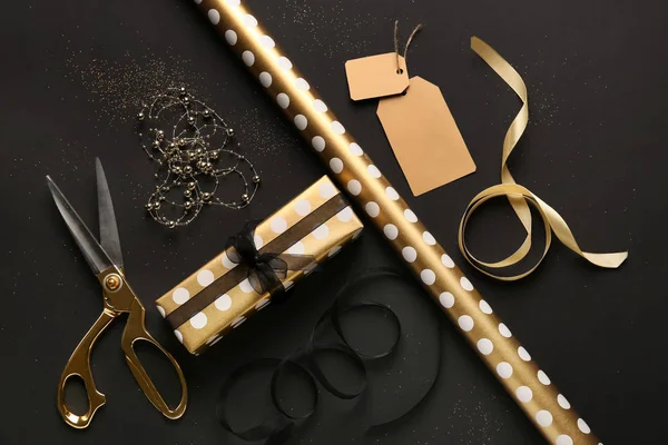 Koyu arka plan üzerinde malzeme sarma ile Noel hediye kutusu