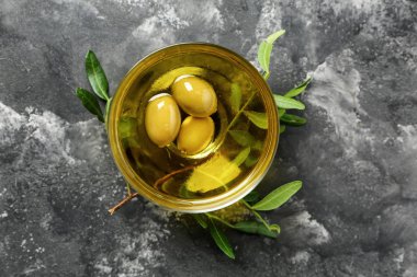 Taze zeytin yağı gri masada kase