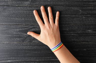 Lgbt gökkuşağı bilezik ahşap arka plan üzerinde kadınla