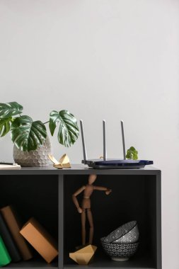 Modern wi-fi router on dark shelf clipart