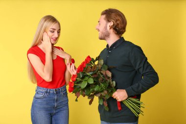 Genç adam onun sevgili renk arka plan üzerinde için teklif