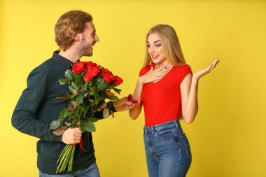 Genç adam onun sevgili renk arka plan üzerinde için teklif