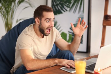 Şok genç adam dizüstü evde kullanma