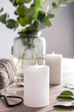 Yanan mumlar ve ahşap masa dallarda okaliptüs vazo