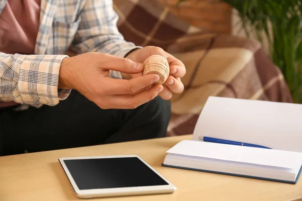 Young man with brain teaser at table indoors